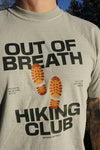T-shirt with 'Out of Breath Hiking Club' design worn by a person outdoors.