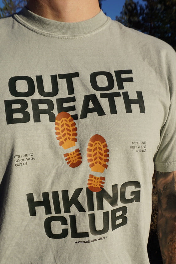 T-shirt with 'Out of Breath Hiking Club' design worn by a person outdoors.