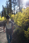 Person walking on a trail through a forest with yellow foliage