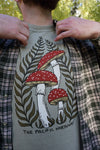 Person wearing a t-shirt with a mushroom design and text 'The Pacific Northwest'.