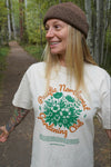 Woman wearing a 'Pacific Northwest Gardening Club' t-shirt in a forest setting