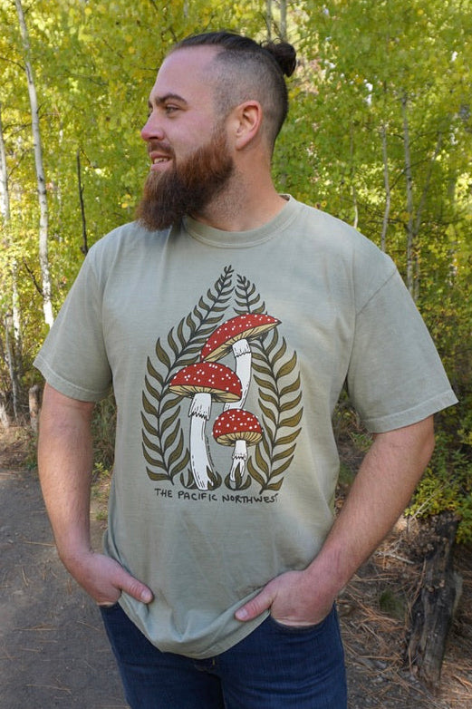 Man wearing a t-shirt with a nature-themed design in a forest setting