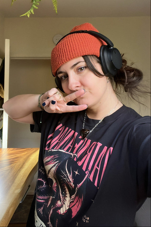 Person wearing headphones and a red beanie in a casual indoor setting