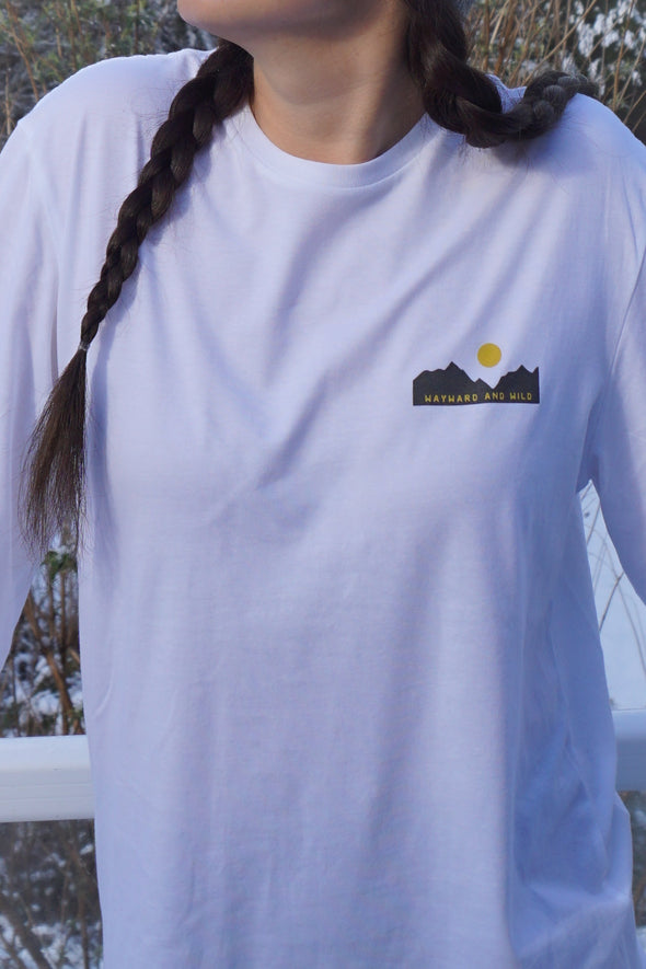 The front of the shirt cropped to show off the left chest of the shirt with Wayward & Wild logo printed in grey and yellow on a small mountain design