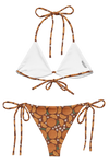 inside of bikini set with white top on the inside and an orange patterned bottom on a white background