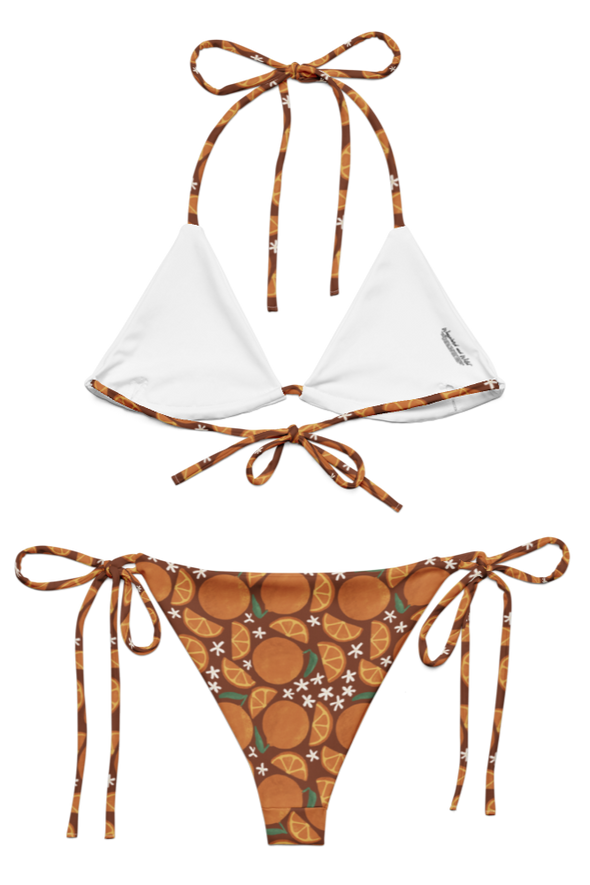 inside of bikini set with white top on the inside and an orange patterned bottom on a white background
