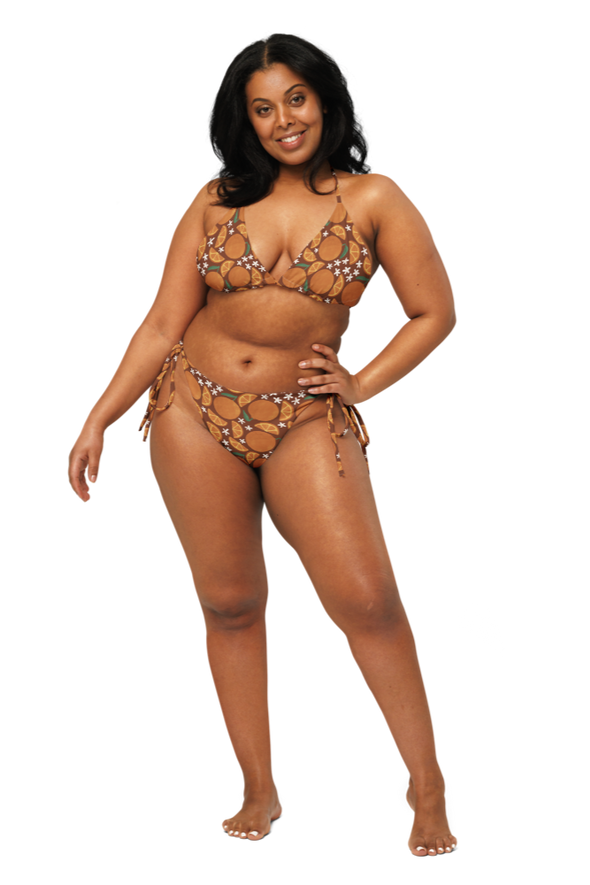Woman wearing an orange fruit style bikini set on a white background