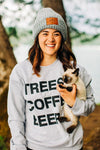 Photo of Stacie wearing the light gray Chunky knit Beanie with a leather patch the has three little pine trees "Wayward & Wild" below the trees and "EST. MMXVI" below that. Stacie is also rocking the TREES COFFE BEER athletic gray crewneck sweatshirt.