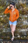 Kolbi facing forward wearing the Orange zip hoodie with jean shorts and sunglasses.